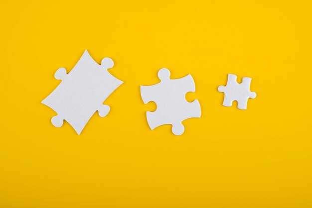 White puzzle pieces and yellow background