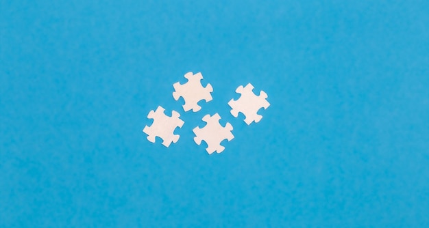 무료 사진 파란색 배경에 흰색 퍼즐이 평평하게 놓여 있습니다.