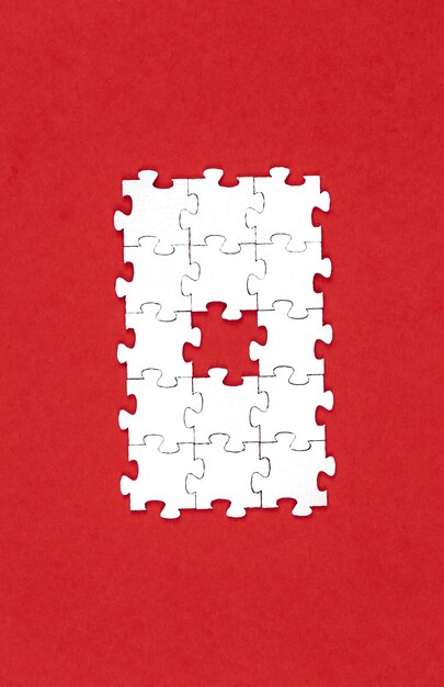 White puzzles on a red background flat lay