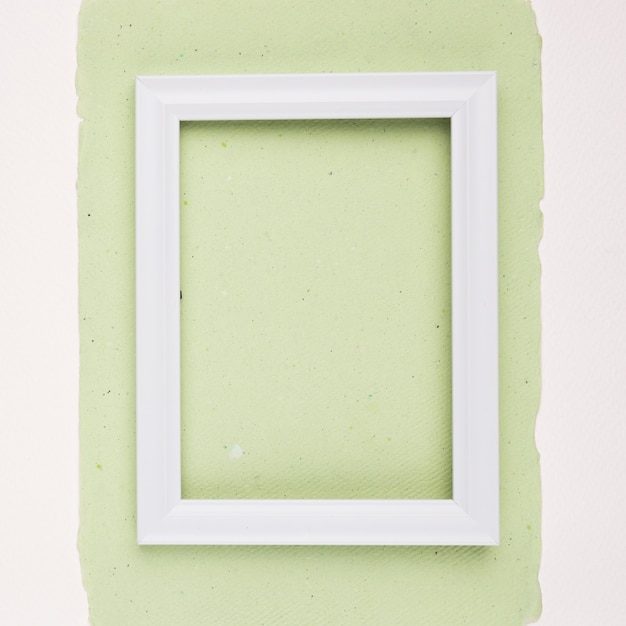 White rectangular border frame on mint green paper on white backdrop