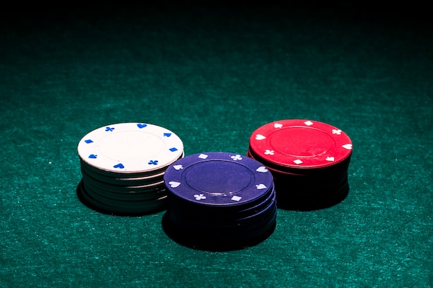 하얀; 녹색 포커 테이블에 빨간색과 파란색 카지노 칩 스택