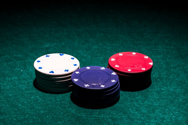 White; red and blue casino chip stack on green poker table