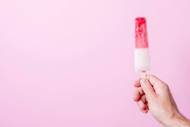 White and red cold ice cream on stick with copy space