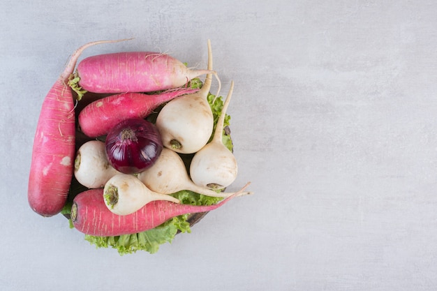 White and red turnips with onion on wooden piece. High quality photo