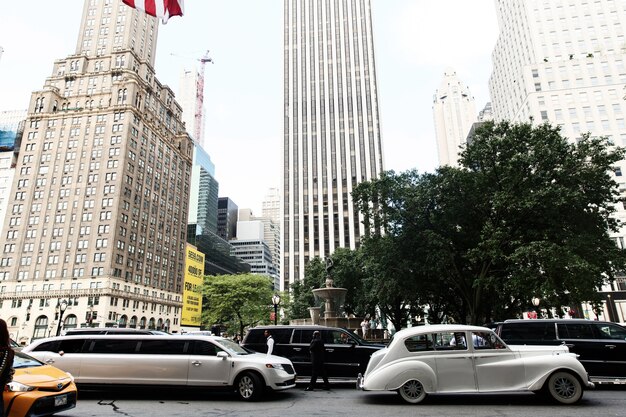 뉴욕의 거리를 따라 흰색 복고풍 자동차와 새로운 리무진 타기