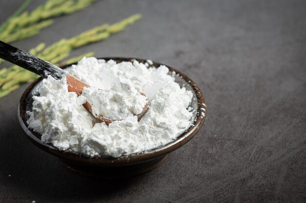 White rice flour on small bowl with rice plant