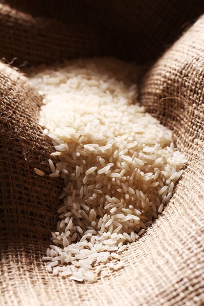 Белые рисовые зерна на мешковине