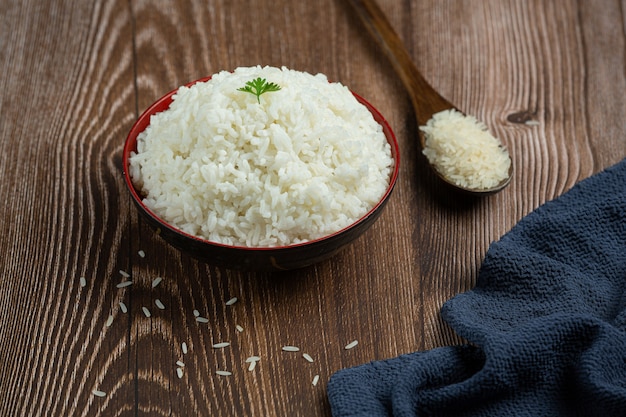 Foto gratuita il riso bianco viene posto in una tazza sul pavimento di legno.