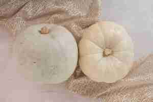 Free photo white ripe pumpkins on white table with burlap.