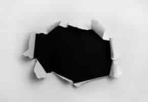 Foto gratuita carta strappata bianca in sfondo nero