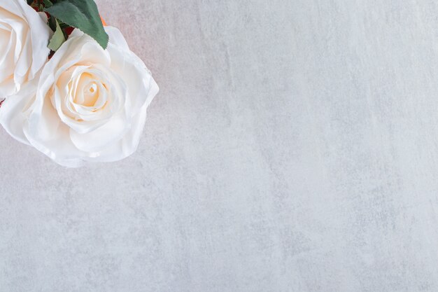白いテーブルの上に、ボウルに白いバラ。