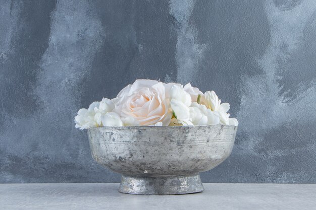 White roses in a iron bowl , on the white background.