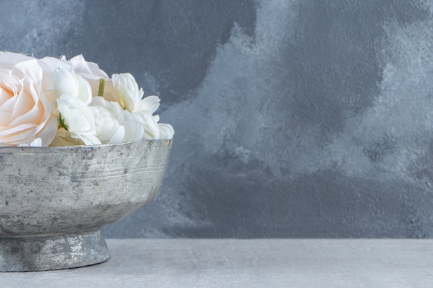 흰색 바탕에 철 그릇에 흰색 장미.