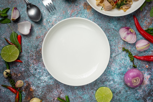 A white round empty  plate among of spices ingredients