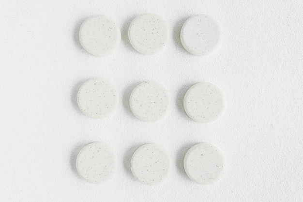 Free photo white round pills arranged on isolated backdrop