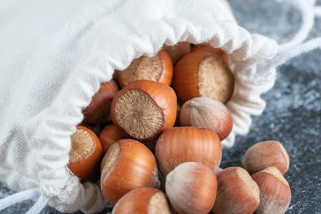 Un sacco bianco pieno di deliziose noci di macadamia.