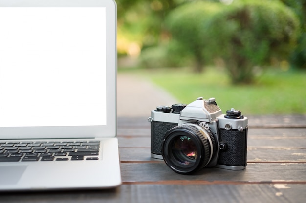 white screen laptop and old vintage camera