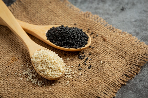 Free photo white sesame and black sesame on dark background