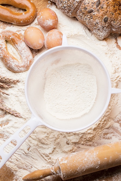 White sieve with flour and bread