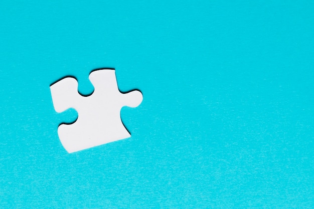 White single puzzle piece on blue background