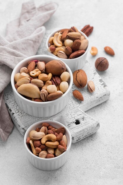 White small bowls filled with assortment of nuts high view