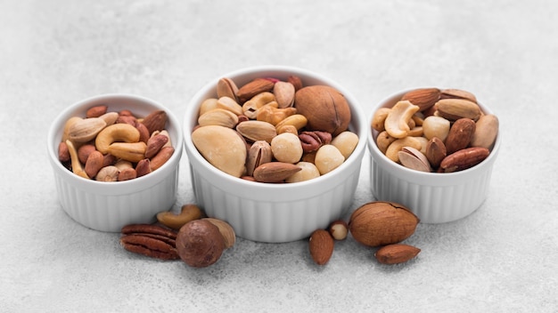 White small bowls filled with assortment of nuts