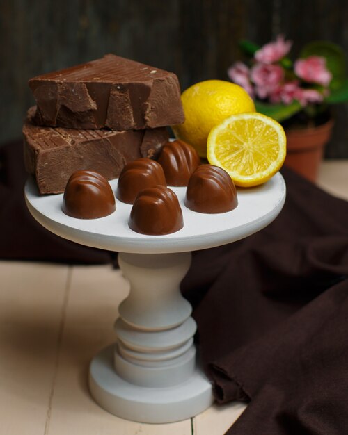 White small cake stand with milk chocolates and lemon on top