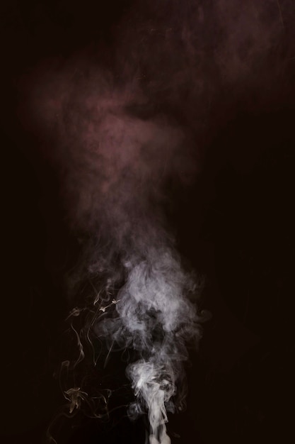 White smoke blowing against black background