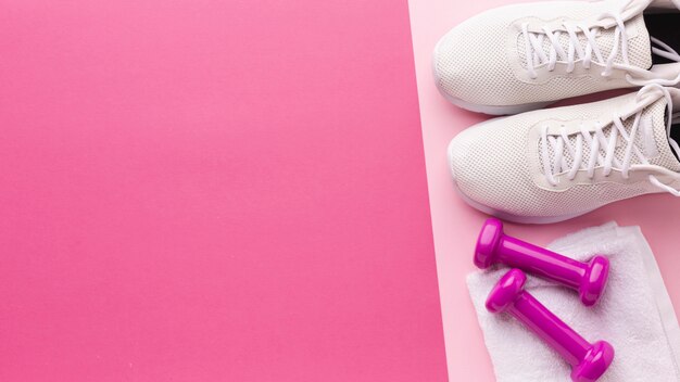 White sneakers and pink weights with copy space