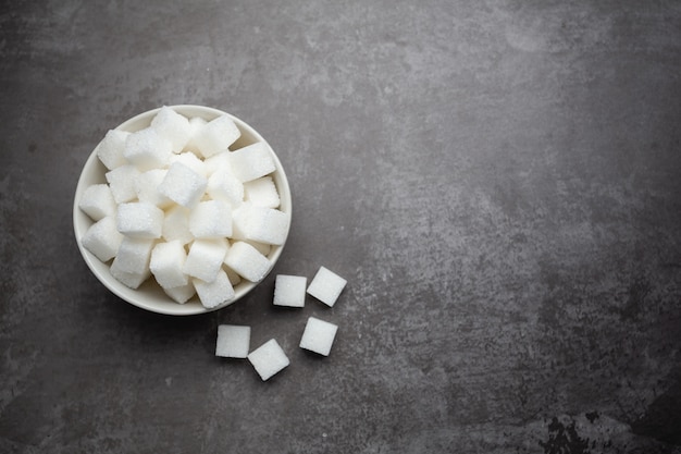 White sugar cubes in bowl on table.