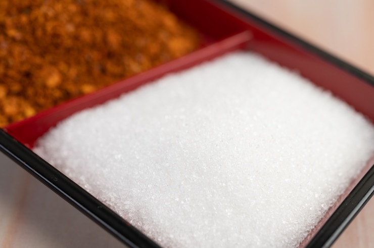 मुफ़्त फोटो white sugar in a cup on the wooden floor.