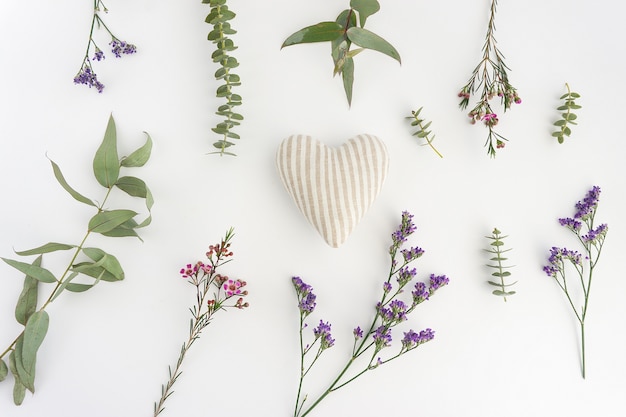 Foto gratuita superficie bianca con fiori e cuore a strisce