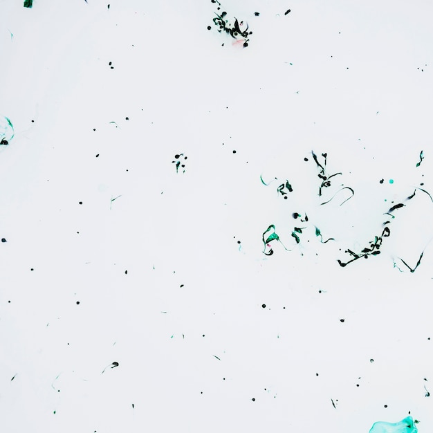 Free photo white surface with green ink drops