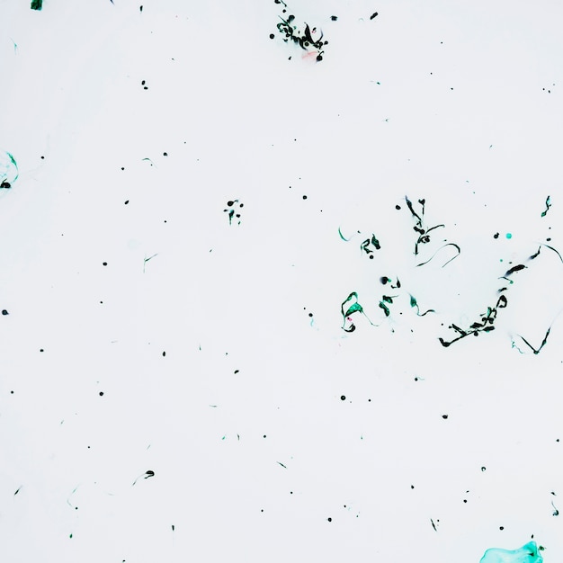 White surface with green ink drops