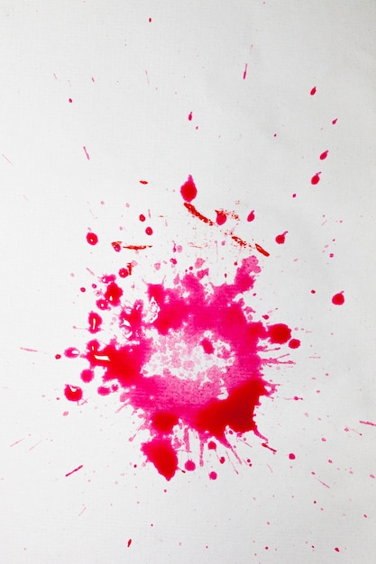 White surface with splashes of pink watercolor