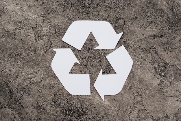 Simbolo bianco di riciclaggio su sfondo sporco