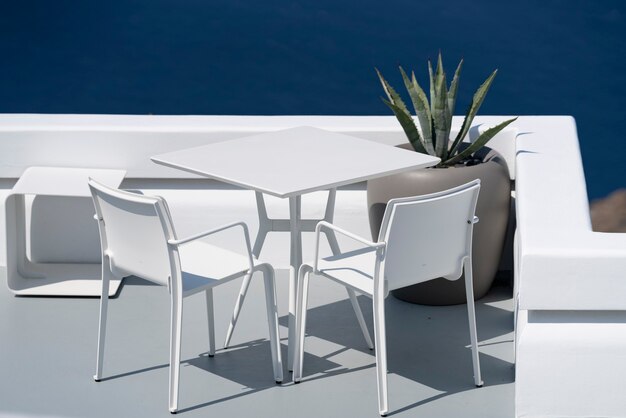 White table and chairs on terrace in Oia, Santorini.