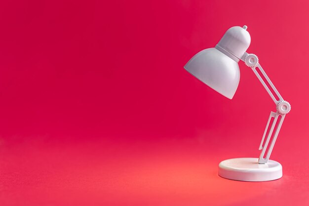 White table lamp on a Viva Magenta background copy space