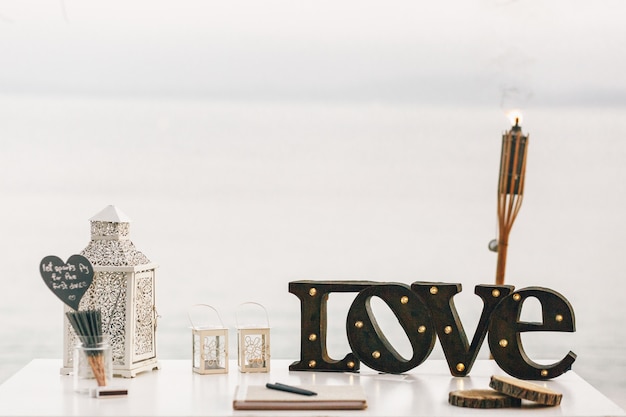 White table with decorative lanterns and steel lettering LOVE