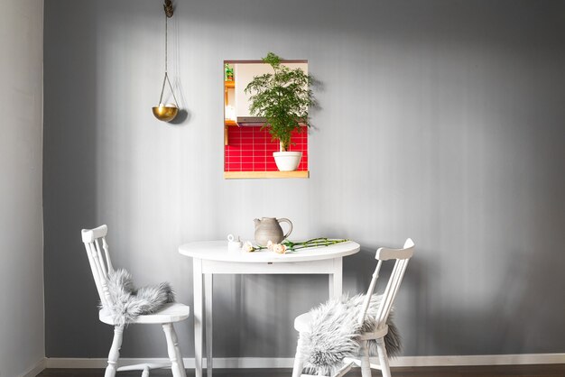 멋진 인테리어와 벽에 그림이있는 방에 두 개의 의자가있는 흰색 테이블