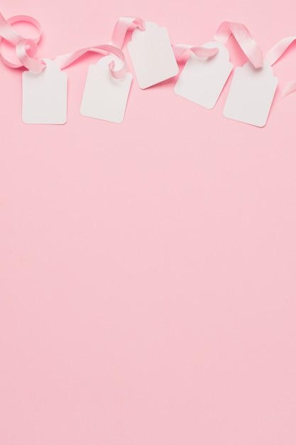 텍스트를위한 공간이있는 배경의 상단에 흰색 태그와 분홍색 리본