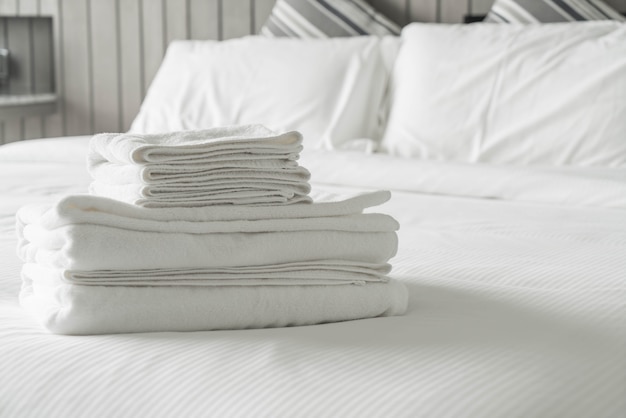 寝室のインテリアのベッドの装飾の上に白いタオル