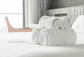 Бесплатное фото Белое полотенце на кровати в интерьере спальни