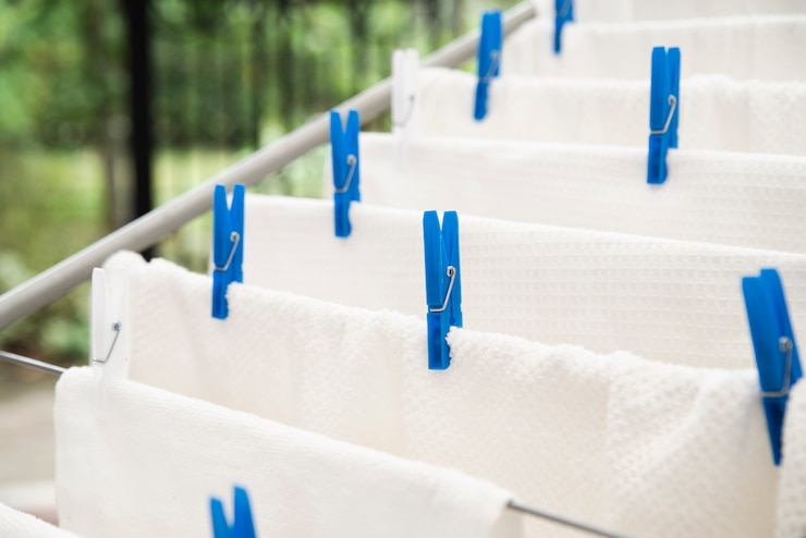Free Photo white towels drying on clotheshorse