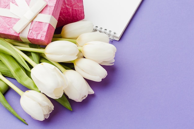 White tulip flowers and pink wrapped gifts