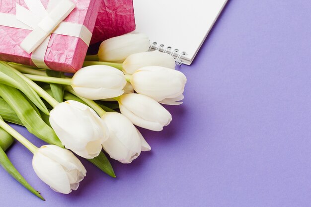 白いチューリップの花とピンクの包まれた贈り物
