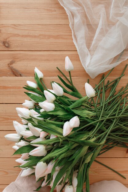 белые тюльпаны на фоне естественного деревянного фона. Весенняя мелодия