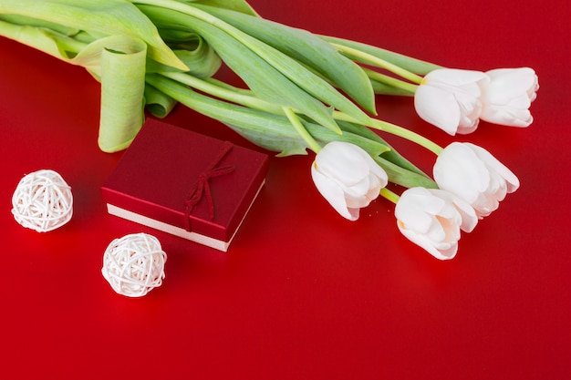 Free photo white tulips with gift on table