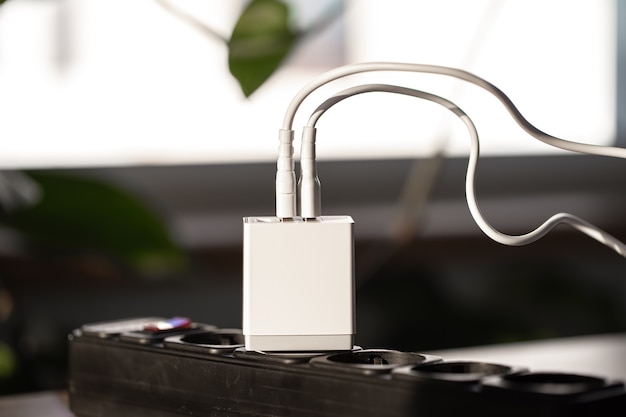 White usb charging for gadgets on a blurred background of the room closeup
