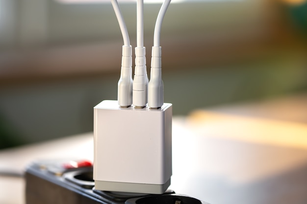 White usb charging for gadgets on a blurred background of the room closeup
